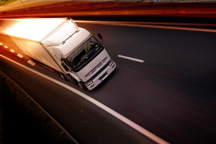 White truck driving on a road with motion blur