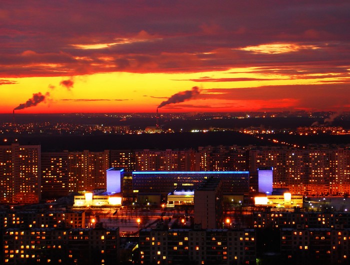 Cityscape at sunset with smoking chimneys