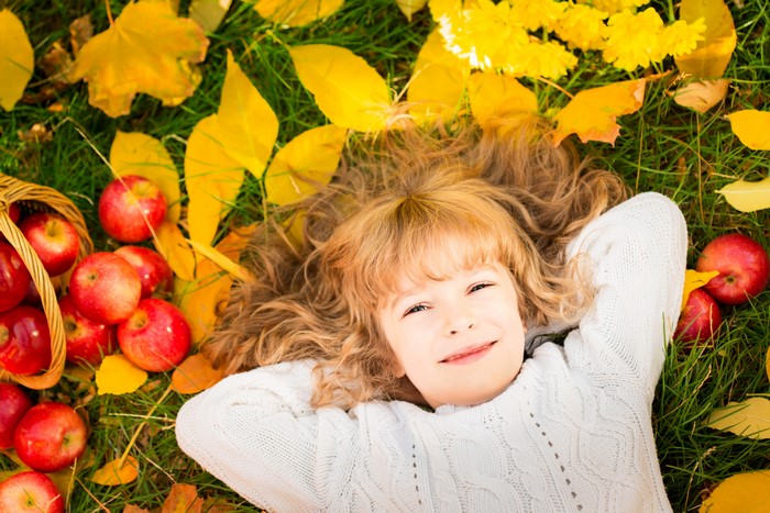 Girl in Autumn with Apples and Foliage