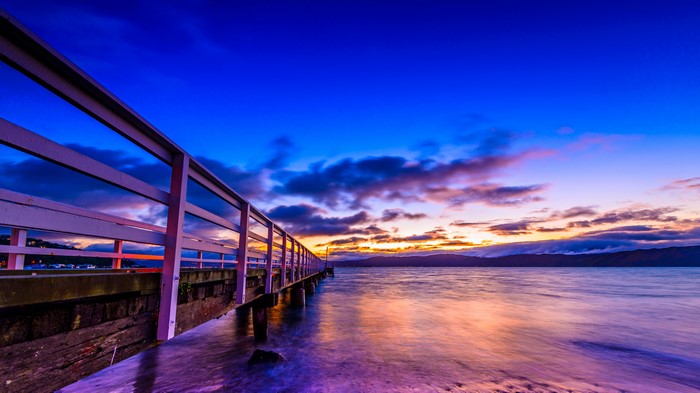 Pier over water at sunset