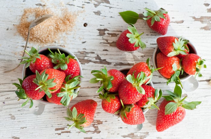 Strawberries and brown sugar on a wooden table