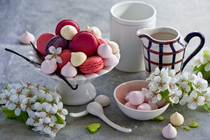 Macarons and meringues on a cake stand with flowers