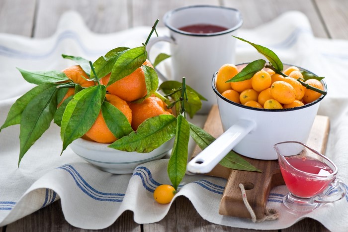 Tangerines and kumquats with leaves and juice