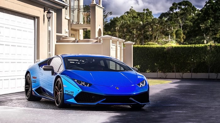 Blue Lamborghini Huracan parked in front of a house