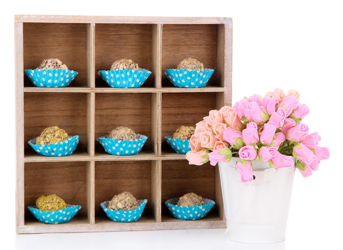 Wooden shelf with candies and pink roses