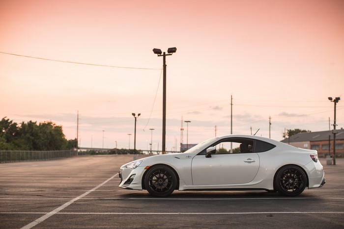 White Subaru BRZ parked in a lot at sunset
