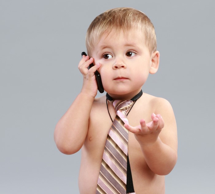 Boy wearing a tie talking on a phone