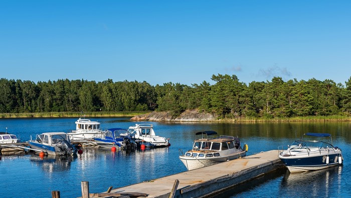 Boats docked in a Swedish marina with forest background