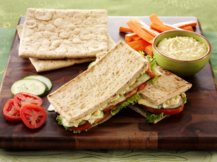 Sandwich with hummus, carrots, tomatoes, and cucumbers