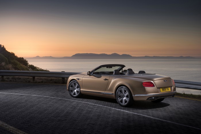 Bentley Continental GTC convertible on a coastal road at sunset