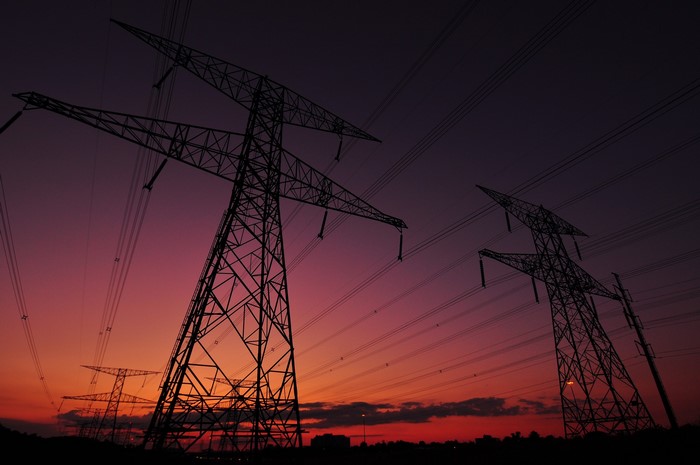 Power lines silhouetted against a sunset sky