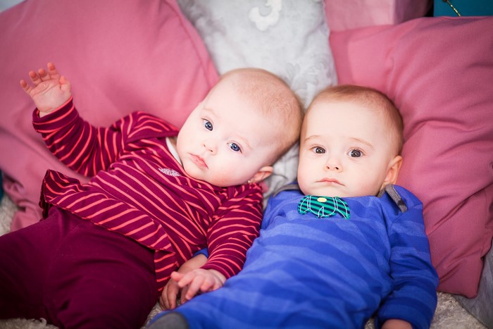 Two infants lying on pillows