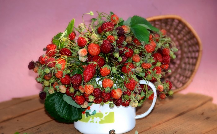 Strawberries in a white mug with a basket