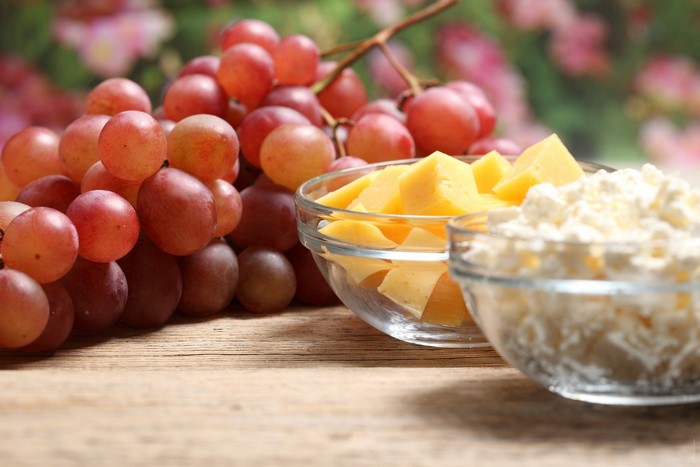 Grapes, Cheese, and Cottage Cheese on a Wooden Table