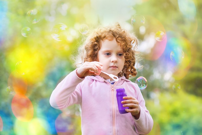 Little girl blowing bubbles