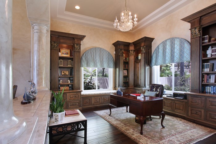 Luxurious home office with dark wood bookshelves and desk
