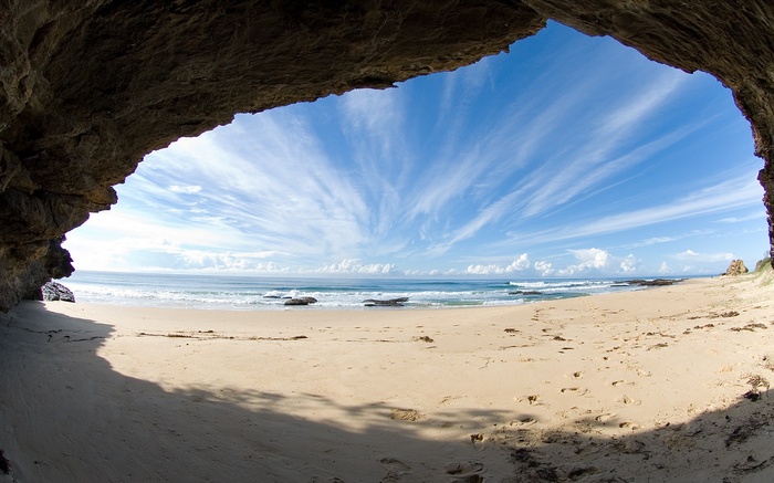 View of a beach and ocean from inside a cave