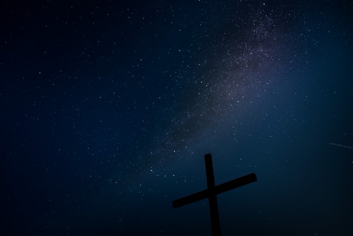 Cross silhouetted against the Milky Way