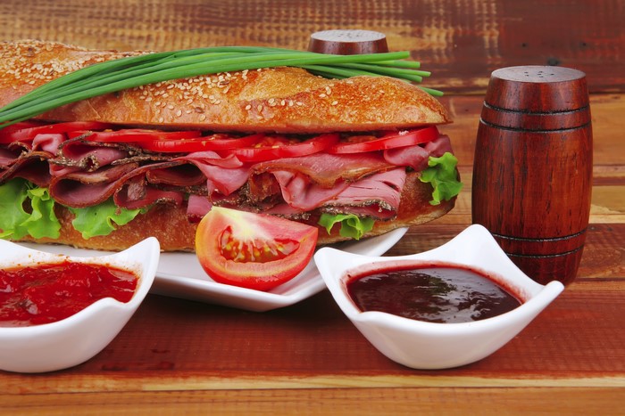 Sub sandwich with meat, tomatoes, lettuce, and chives