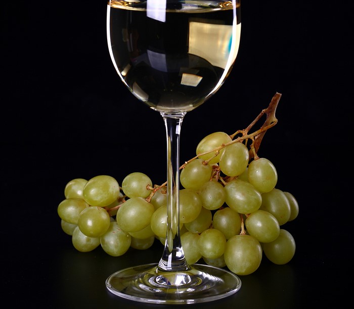 White wine in a glass with green grapes