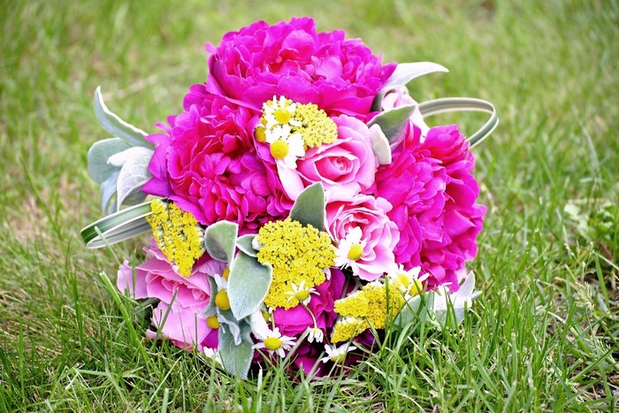 Pink peonies and roses bouquet on grass