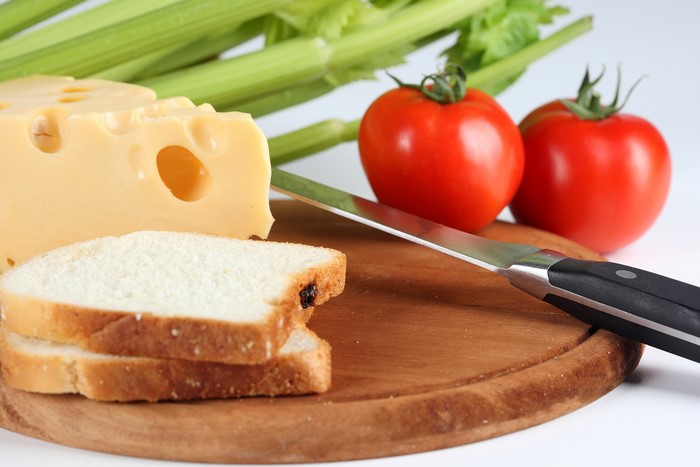 Cheese, Bread, Tomatoes, Celery, and Knife on Cutting Board
