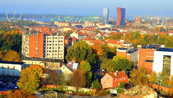 Autumn cityscape with port cranes and modern buildings