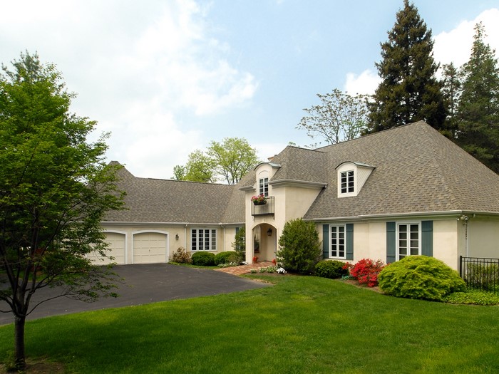 Cream-colored house with garage and manicured lawn