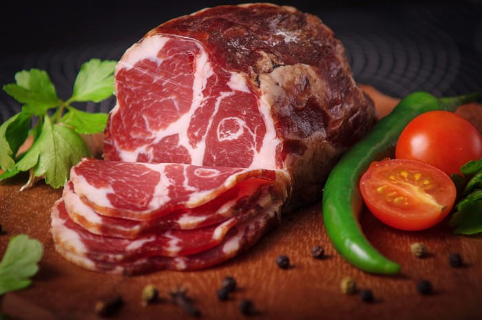 Sliced cured meat with tomatoes and peppers