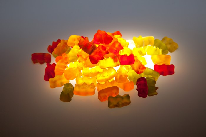 Pile of colorful gummy bears illuminated from behind