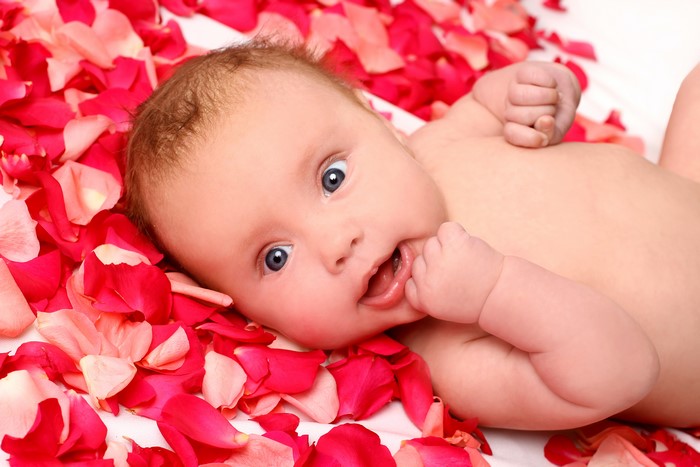 Baby lying on rose petals