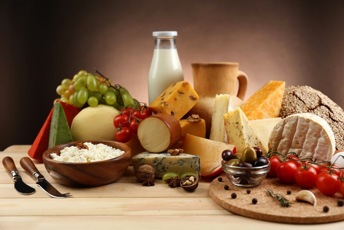 Still-life of cheese, tomatoes, milk, and grapes