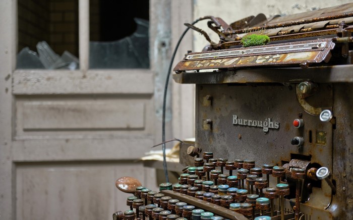 Abandoned Burroughs typewriter with moss