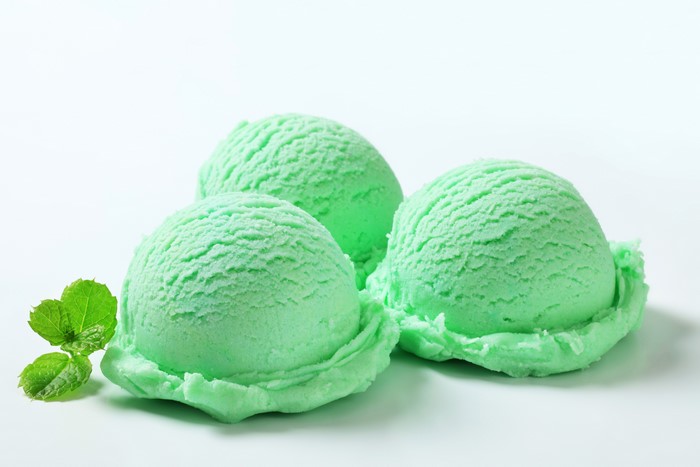 Three scoops of mint ice cream with mint leaves