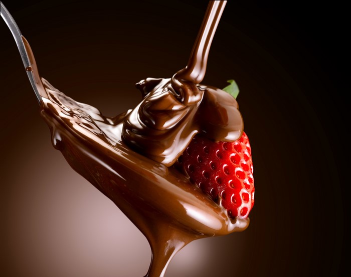 Strawberry dipped in chocolate on a spoon