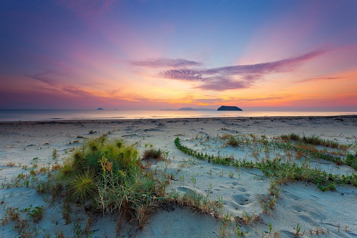 Beach at sunset with islands on the horizon