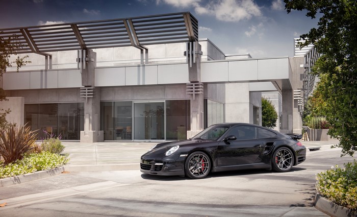 Black Porsche 997 Turbo parked outside modern building