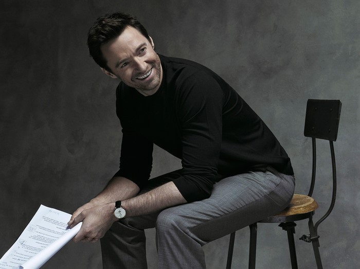 Hugh Jackman sitting with papers