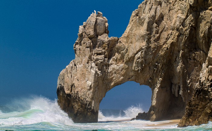 Arch Rock formation with crashing waves