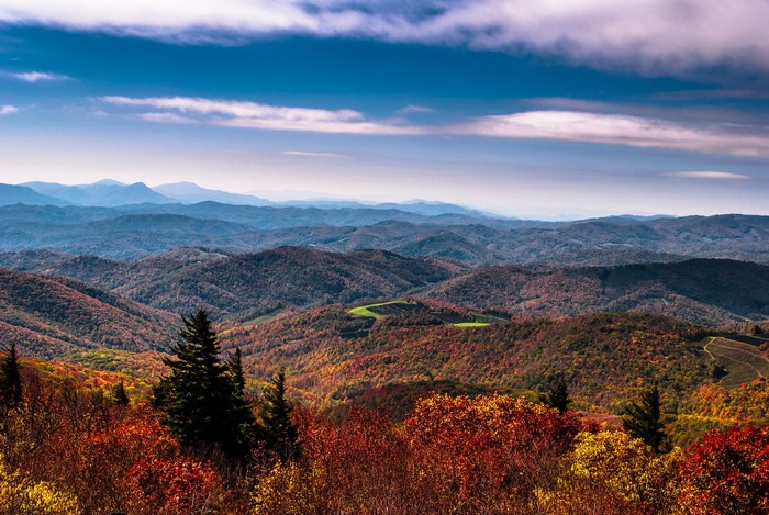 Autumn mountain range with colorful trees and blue sky