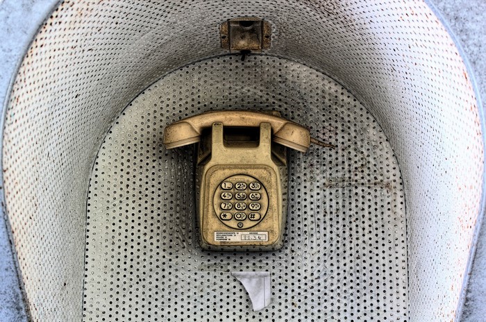 Retro rotary telephone in a perforated enclosure