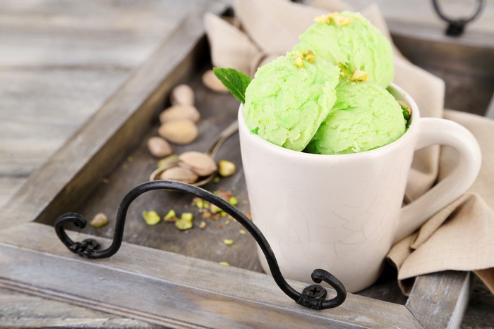 Pistachio ice cream in a mug on a tray