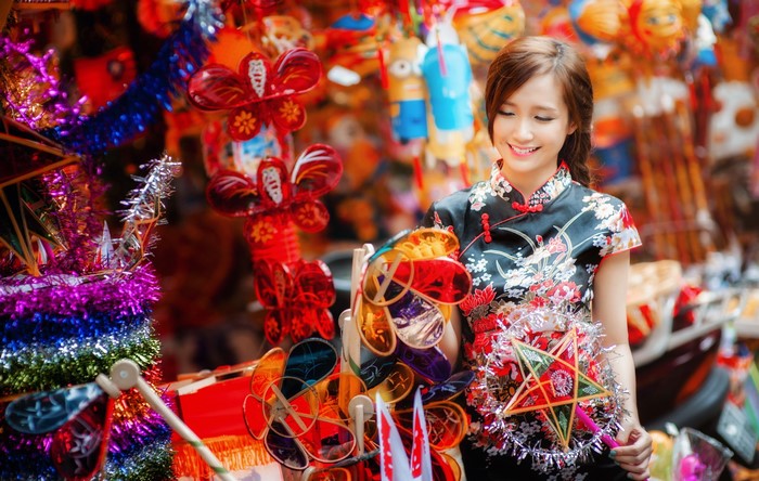 Young woman in traditional dress holding lanterns