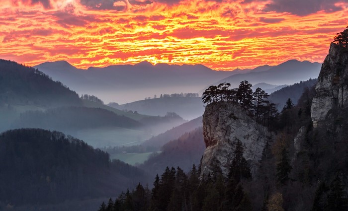 Mountains with fog and dramatic sunset sky