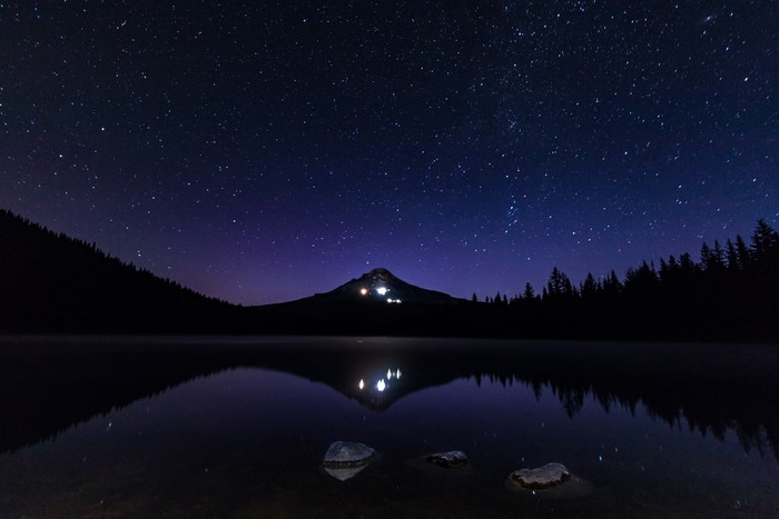 Night sky over a mountain lake with stars