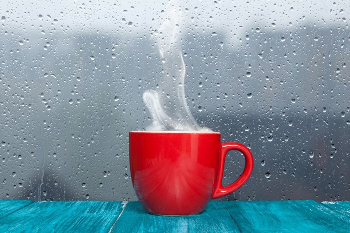 Red cup with steam on a rainy day