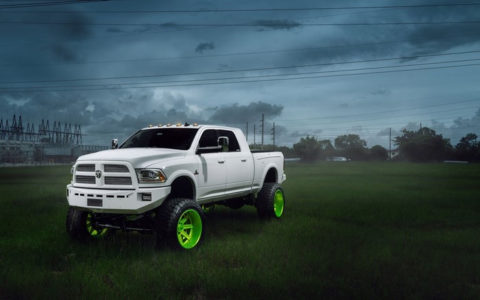 White Ram 2500 truck with green rims on grass