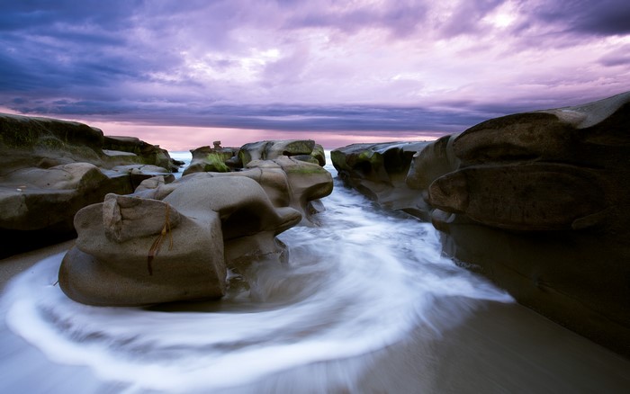Rocky coastline with waves at sunset