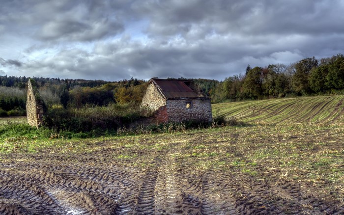 Abandoned stone building in a muddy field