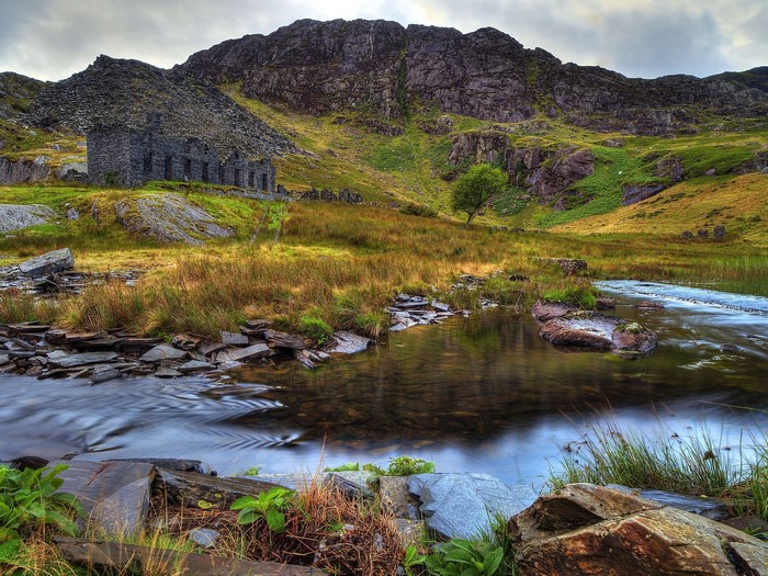 Abandoned stone building by a mountain river